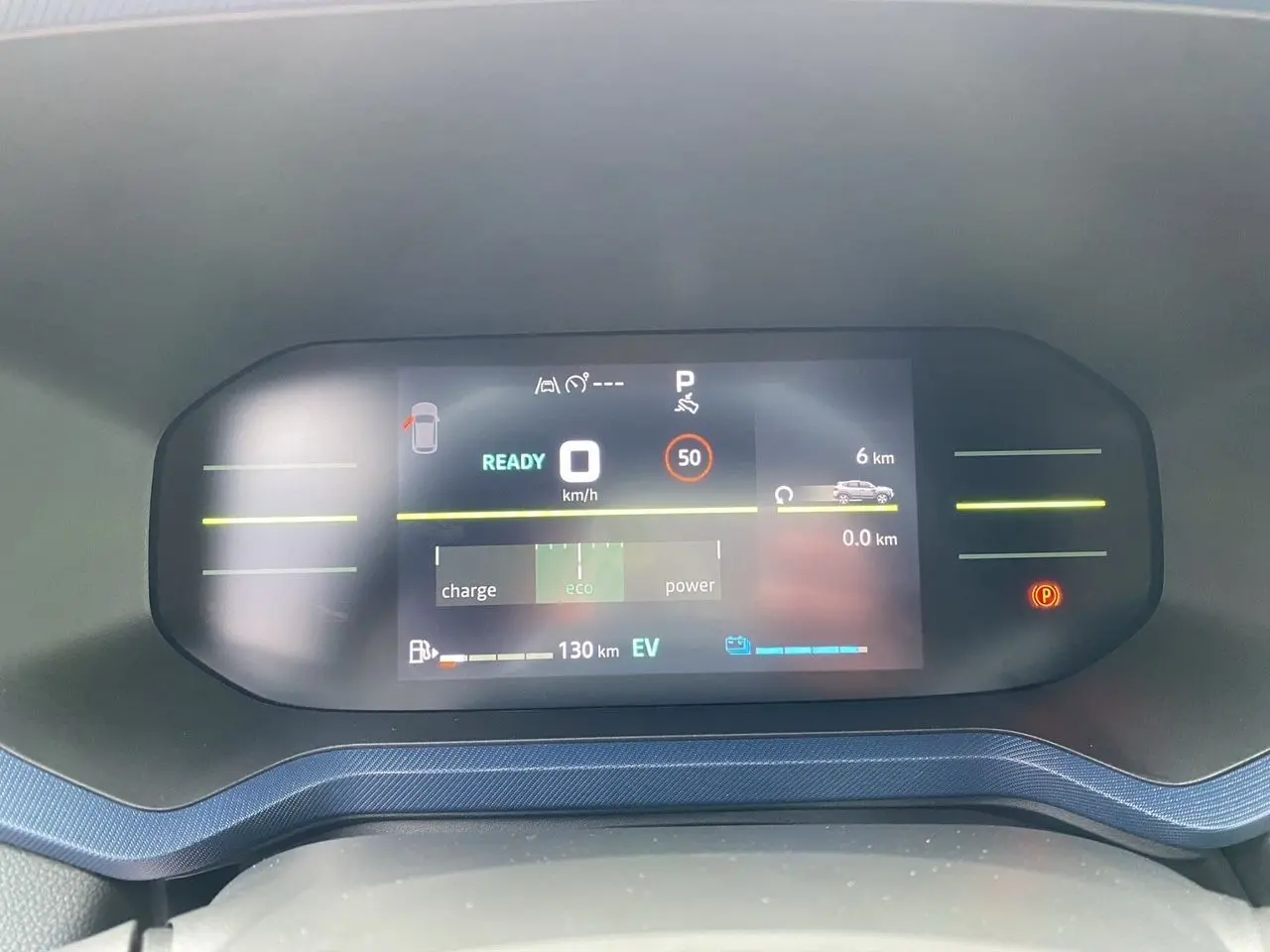 Tableau de bord numérique du Dacia Duster hybride 2025 affichant la vitesse, autonomie et mode éco en vue frontale.