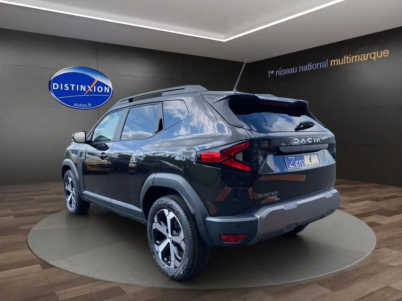 Vue 3/4 arrière droite du Dacia Duster hybride noir avec jantes alliage et détails de protection plastique gris.