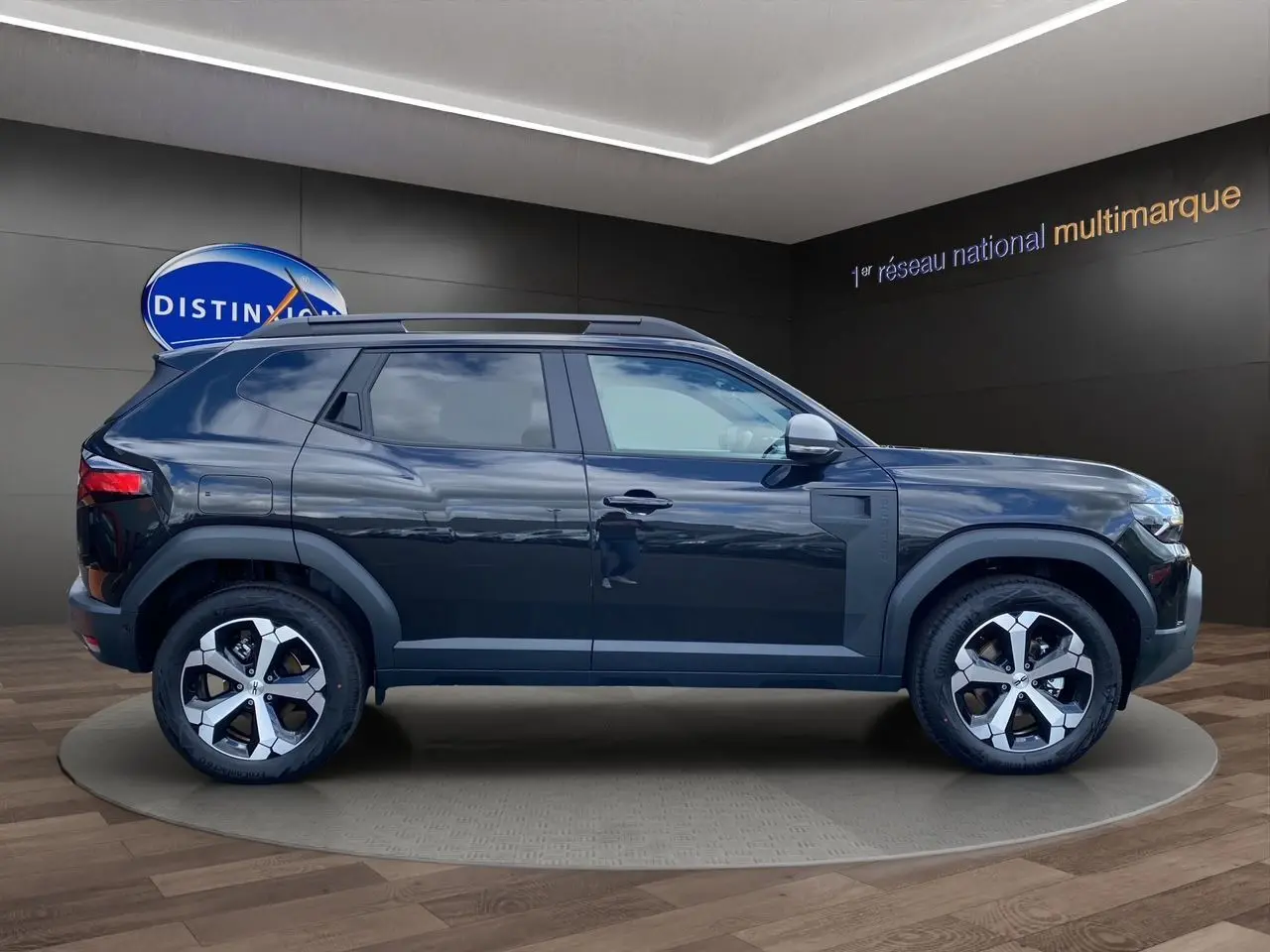 Profil côté gauche du Dacia Duster hybride noir 2025 avec jantes alliage et barres de toit visibles.