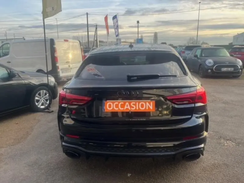 Vue arrière d'une Audi RS Q3 Sportback noire Mythic avec feux LED et double sortie d'échappement sportive.