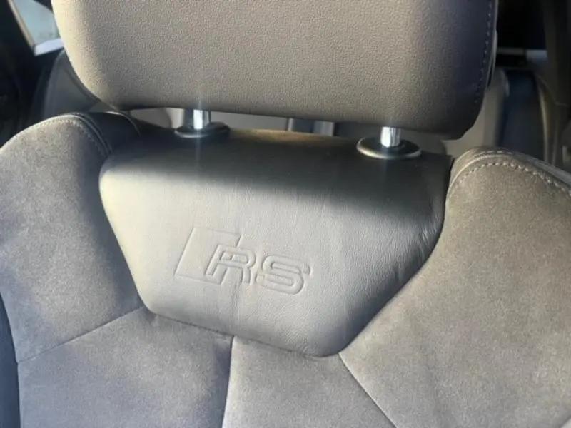 Gros plan sur l'appui-tête avant en cuir noir avec logo RS embossé, intérieur de l'Audi RS Q3 Sportback 2020.