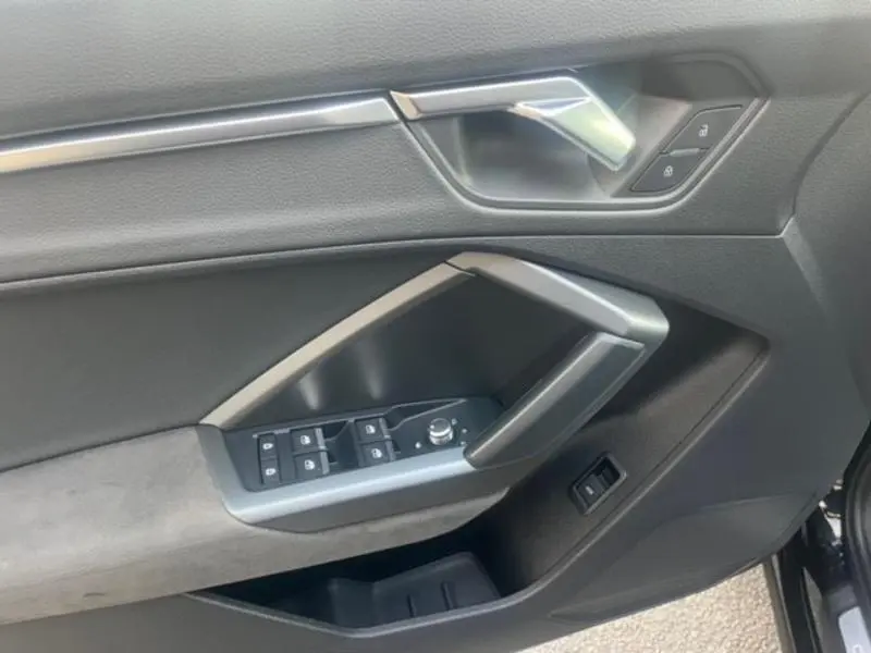 Poignée intérieure côté gauche de la porte avant noire avec commandes de vitres et verrouillage sur Audi RS Q3 Sportback 2020.