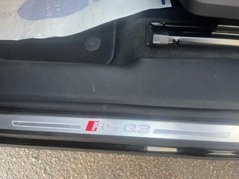 Gros plan sur la plaque de seuil de porte avec logo RS Q3, intérieur noir et extérieur Noir Mythic visible en bas.