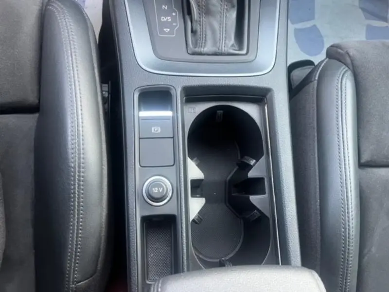 Vue plongeante sur la console centrale noire de l'Audi RS Q3 Sportback 2020 avec porte-gobelets et accoudoirs cuir.