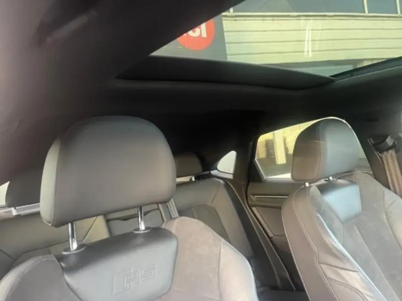 Intérieur noir de l'Audi RS Q3 Sportback 2020, vue sur les sièges avant sport avec logo RS et toit ouvrant panoramique.