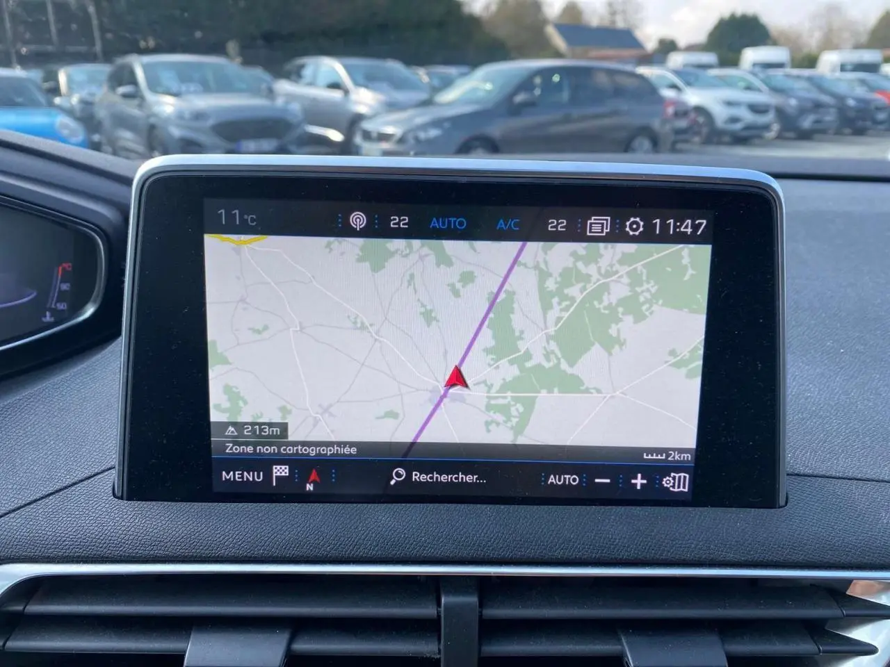 Écran tactile du système de navigation 3D connecté dans le tableau de bord d'une Peugeot 3008 blanche de 2018.