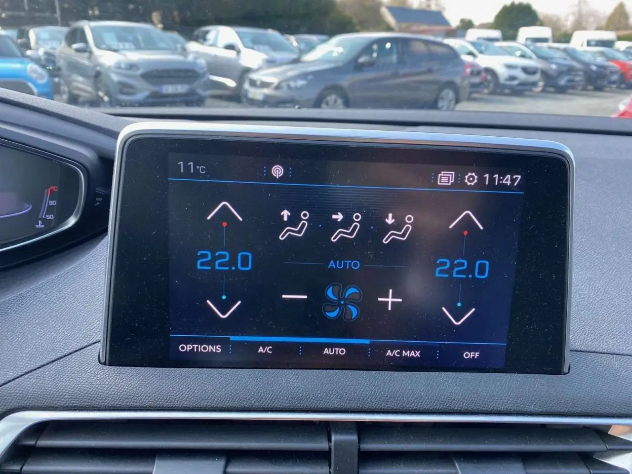 Écran tactile du système de climatisation automatique bi-zone du Peugeot 3008 blanc, affichant 22°C côté gauche et droit.