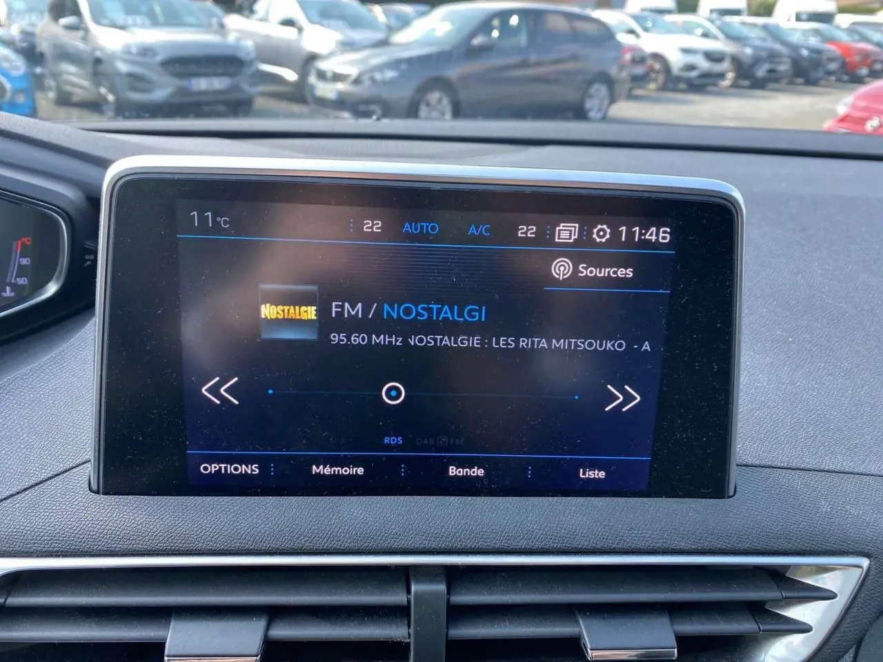 Écran tactile central du Peugeot 3008 blanc 2018 affichant la radio FM Nostalgie à 11h46 en extérieur.