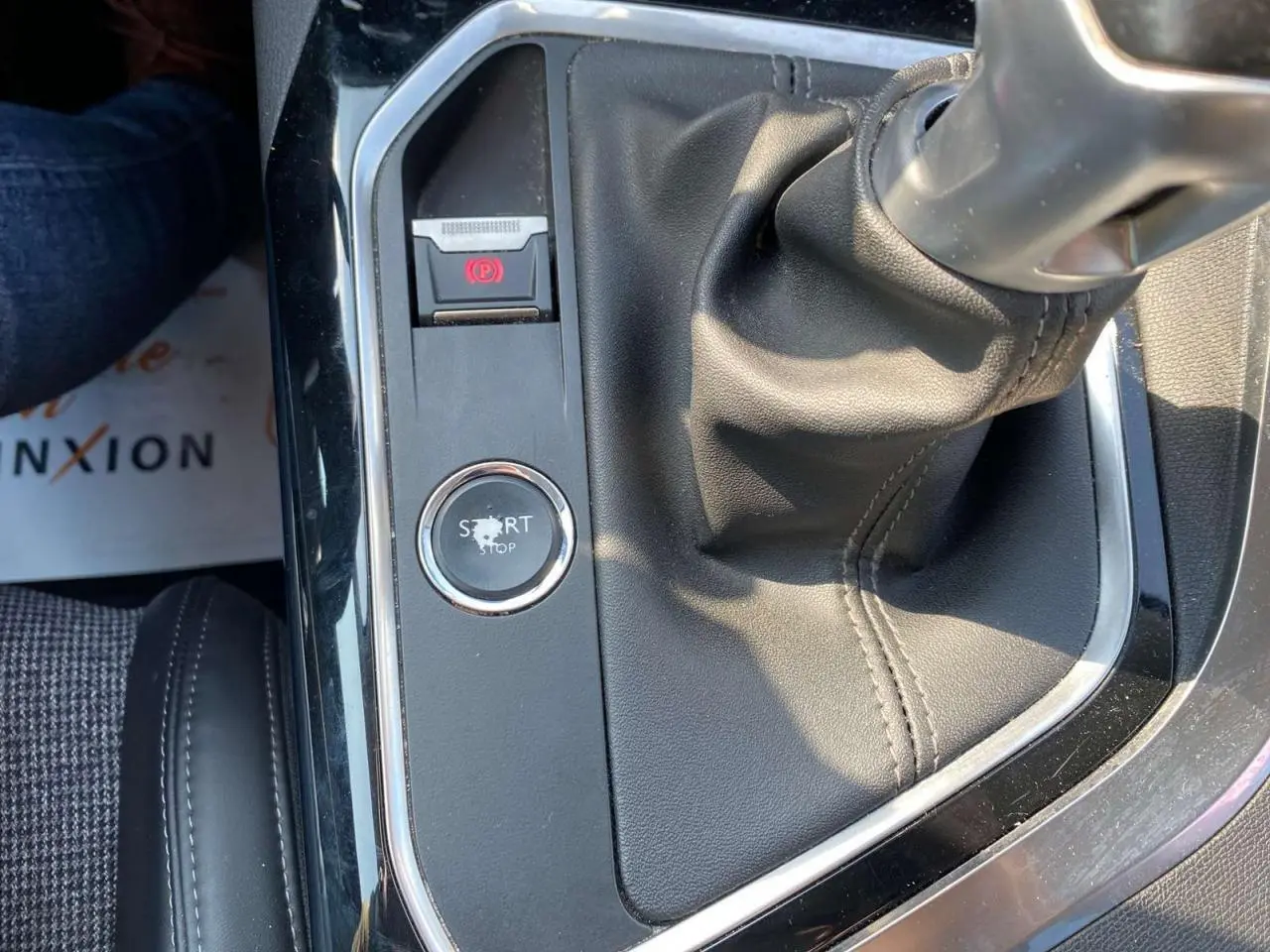 Gros plan sur la console centrale du Peugeot 3008 blanc de 2018, montrant le levier de vitesse manuel et le bouton start/stop.