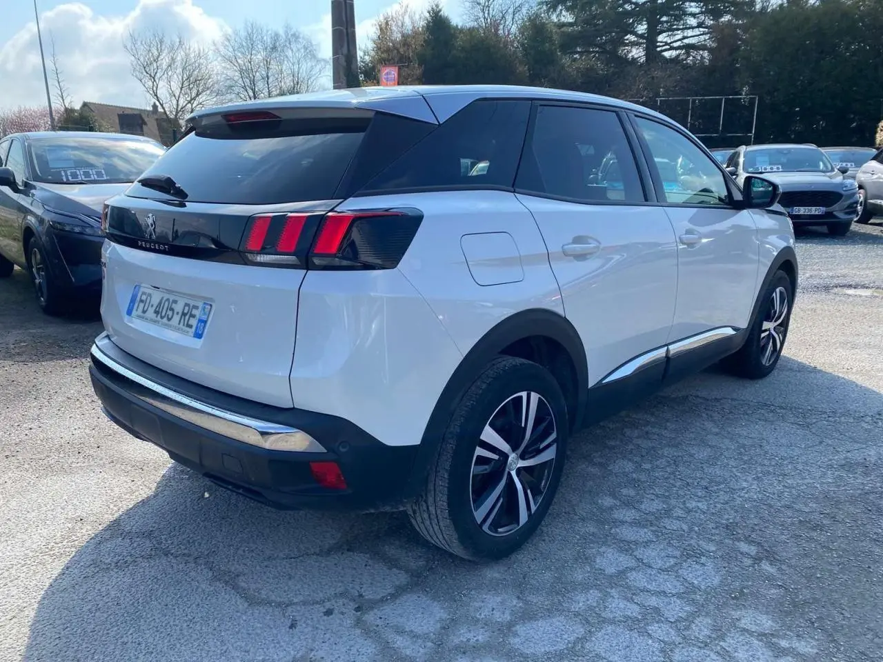 Vue 3/4 arrière droite d'un Peugeot 3008 blanc Banquise avec vitres surteintées et feux arrière à trois griffes rouges.