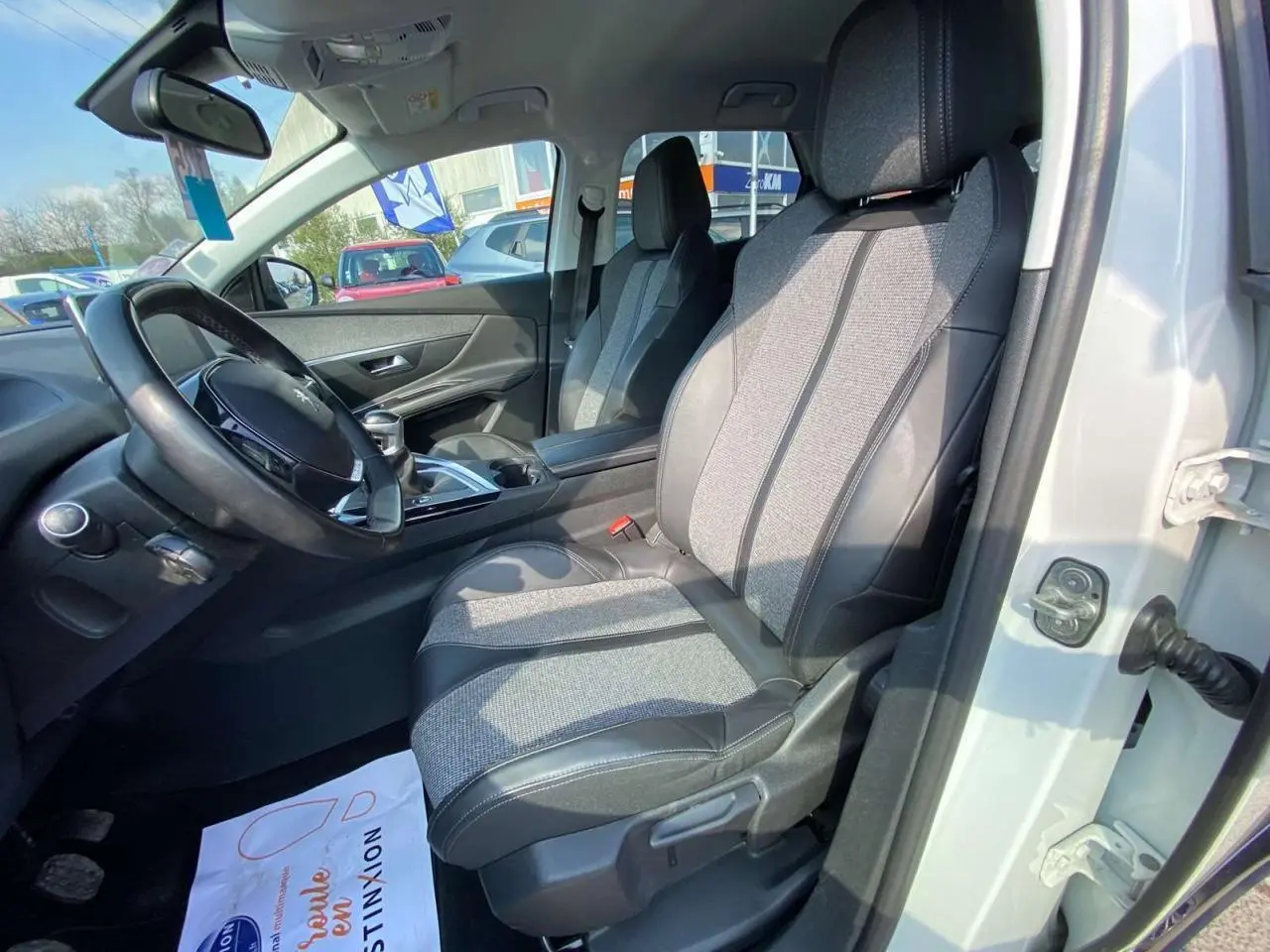 Intérieur avant droit du Peugeot 3008 blanc 2018, sièges en tissu et cuir noir avec tableau de bord visible.