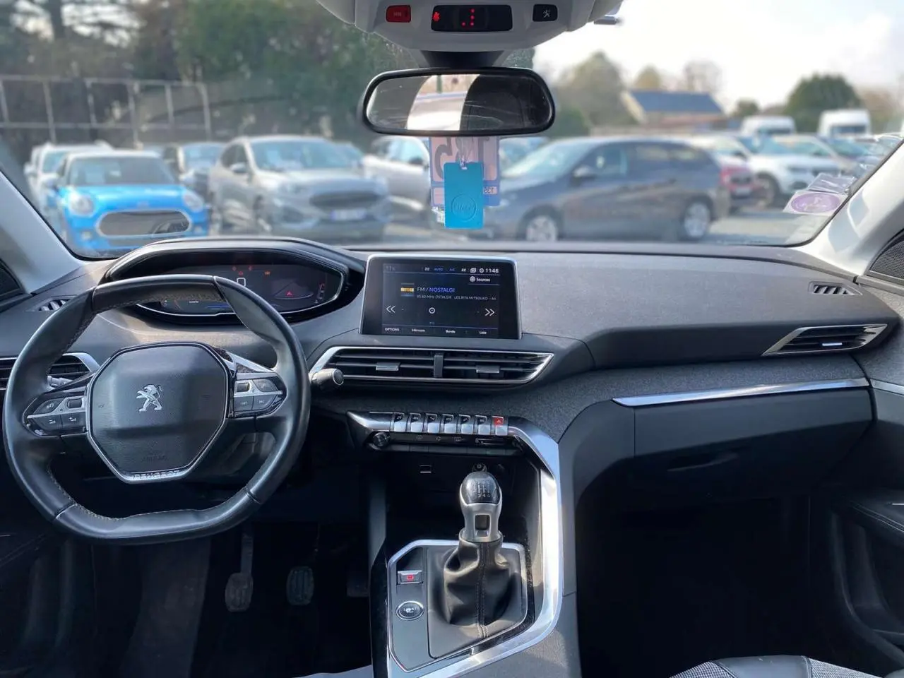 Intérieur du Peugeot 3008 blanc 2018 vu de face, tableau de bord moderne avec écran central et boîte manuelle.