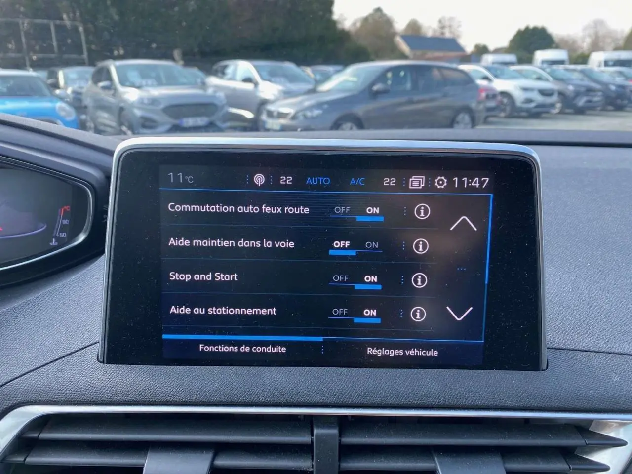 Écran tactile central du tableau de bord du Peugeot 3008 blanc de 2018 affichant les aides à la conduite activées.