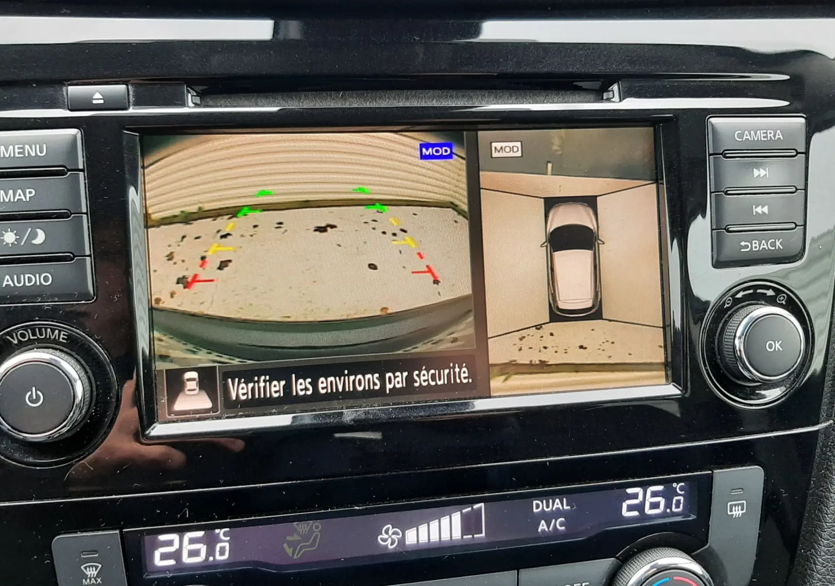 Vue rapprochée de l’écran multimédia du Nissan Qashqai noir 2020 montrant la caméra de recul et l’affichage 360° avec commandes climatisation.