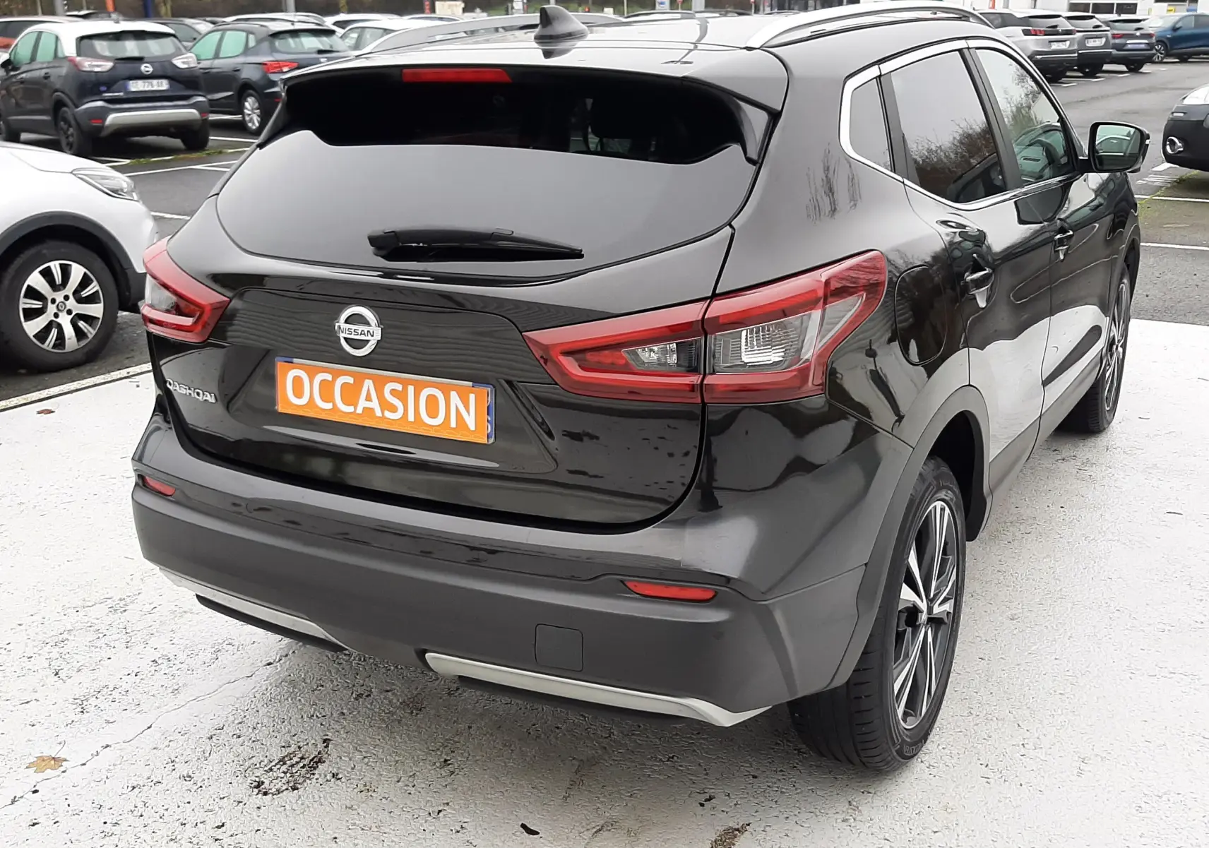 Vue 3/4 arrière droite d'un Nissan Qashqai noir 2020 avec feux arrière LED et plaque "OCCASION" visible.