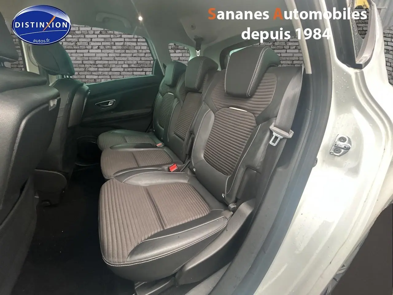 Vue intérieure côté droit sur les sièges arrière en sellerie mixte TEP/tissu carbone foncé d’un Renault Scénic blanc.