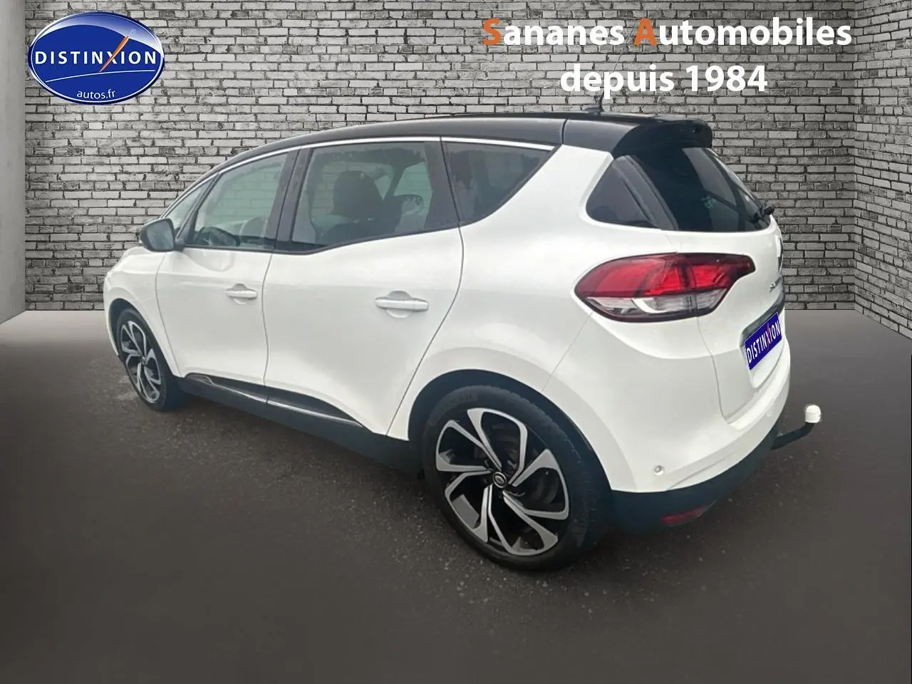 Renault Scenic blanc nacré vue 3/4 arrière droit avec toit noir étoilé et jantes alliage 20 pouces.