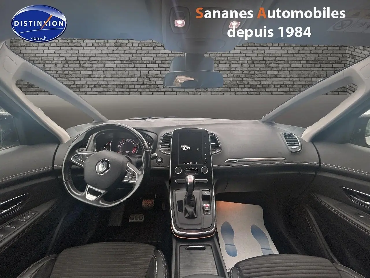 Vue intérieure avant du Renault Scénic 2020, tableau de bord noir avec écran tactile vertical et volant multifonctions.