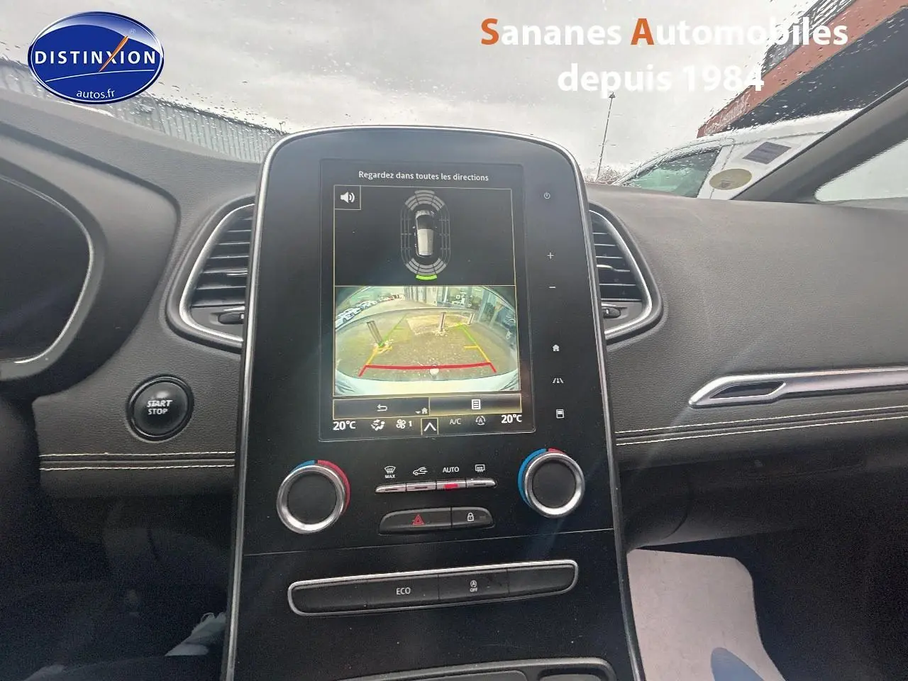 Vue intérieure centrée sur la console centrale du Renault Scenic blanc 2020 avec écran tactile affichant la caméra de recul.
