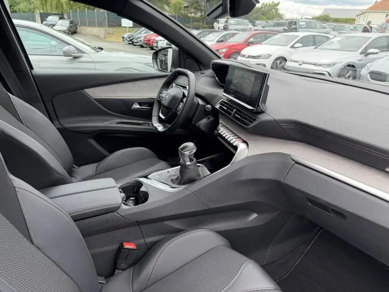 Vue intérieure côté conducteur du Peugeot 3008 1.2 PureTech 130ch gris Platinium, avec volant compact et boîte manuelle.