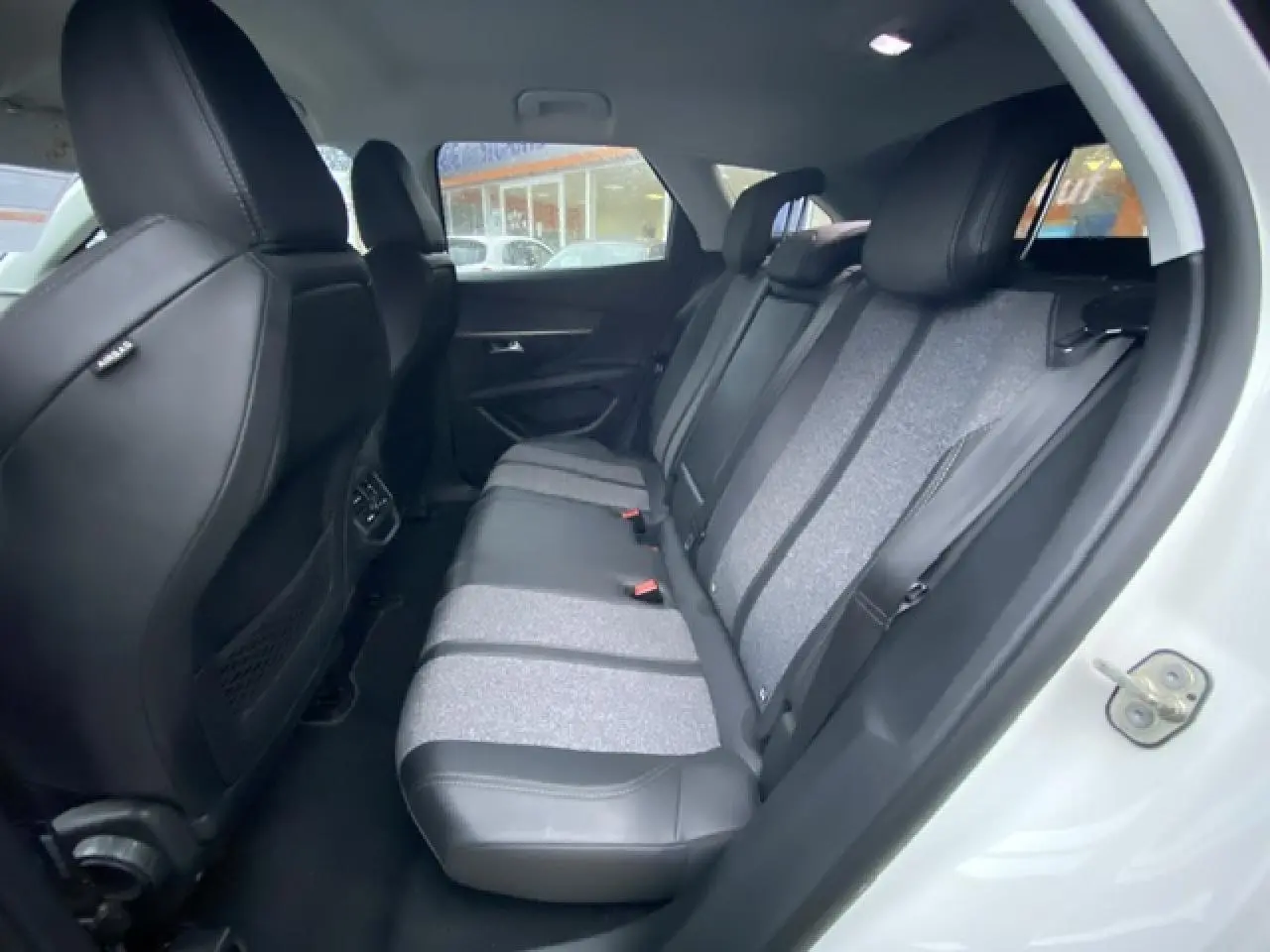Vue intérieure côté droit montrant la banquette arrière bi-matière noire et grise du Peugeot 3008 blanc 2017.