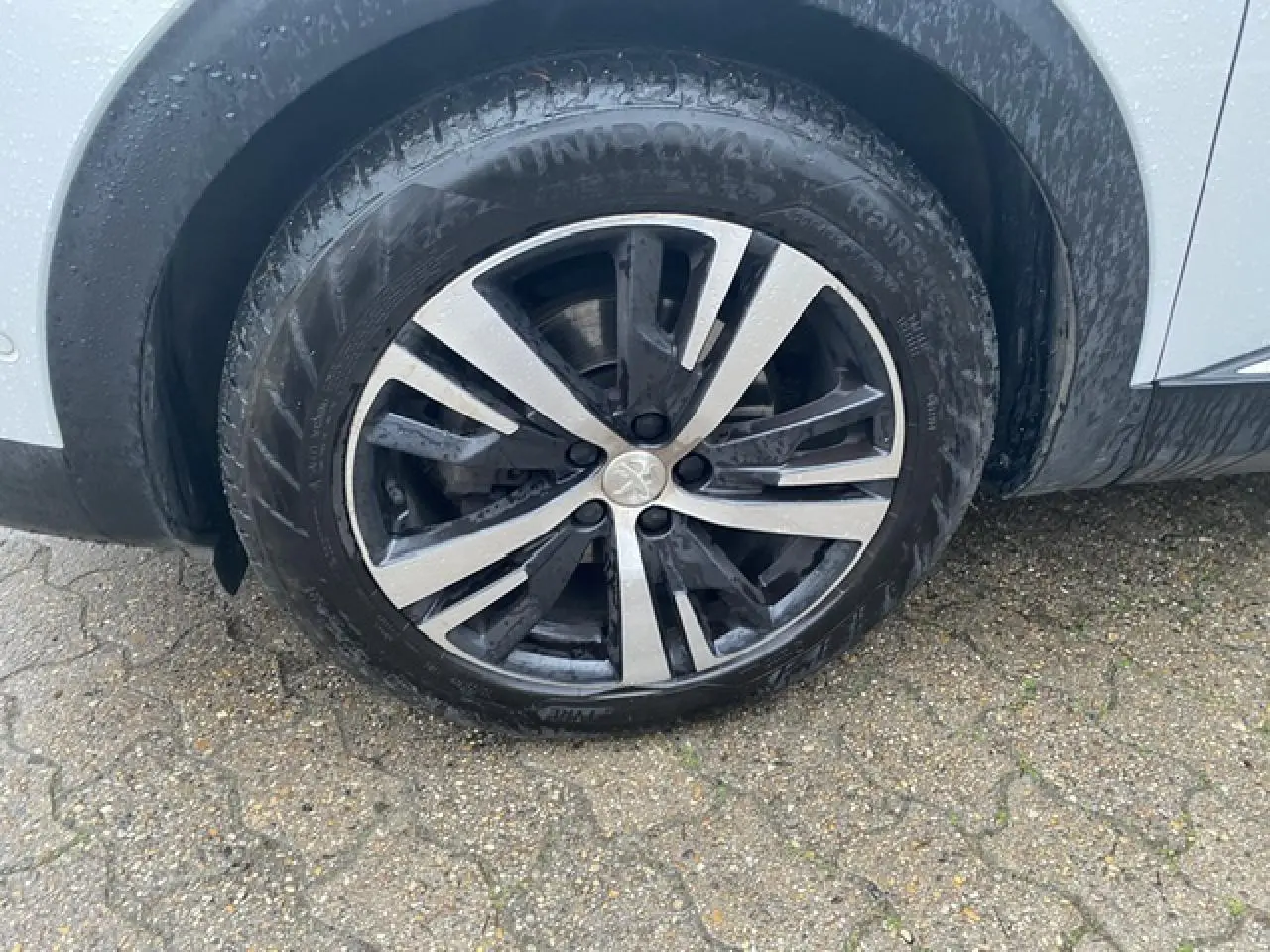 Gros plan sur la jante alliage bi-ton diamantée 18 pouces côté arrière droit du Peugeot 3008 blanc.