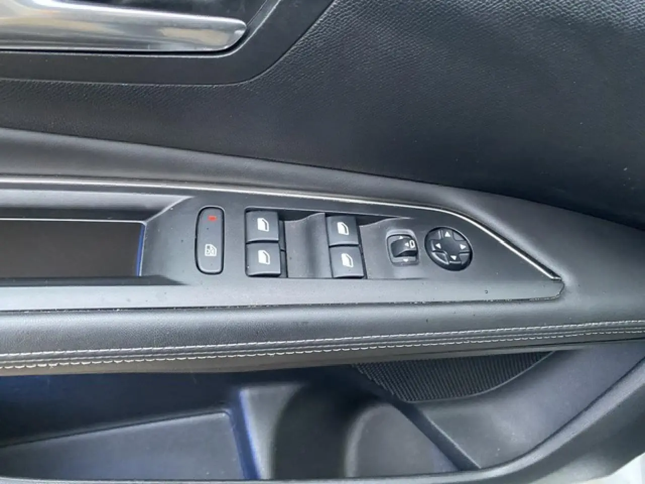 Gros plan sur les commandes de lève-vitres et réglage des rétroviseurs côté conducteur d'un Peugeot 3008 blanc.