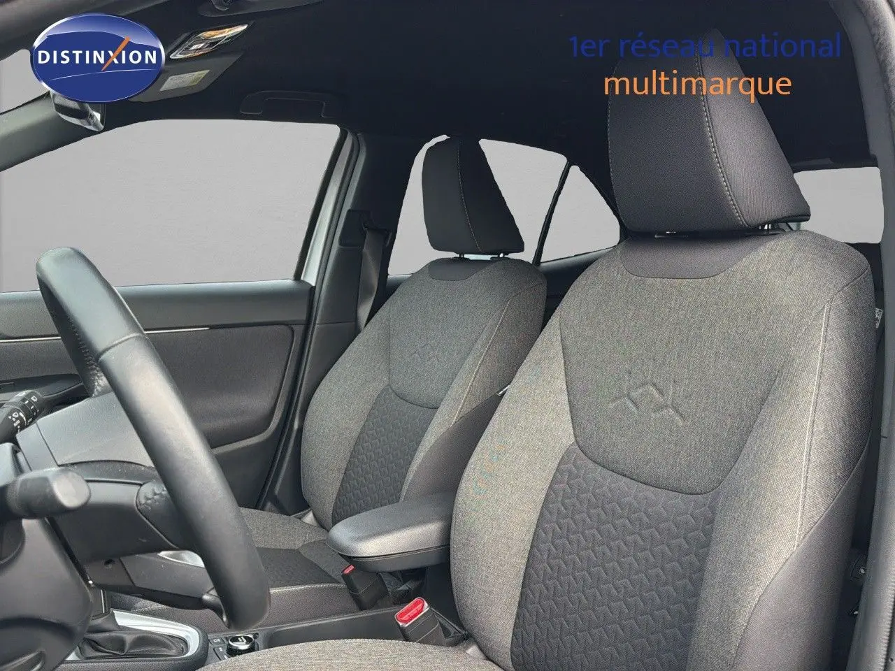 Vue intérieure côté conducteur de la Toyota Yaris Cross 116h Design AWD-i 2023 avec sièges tissu gris et noir.