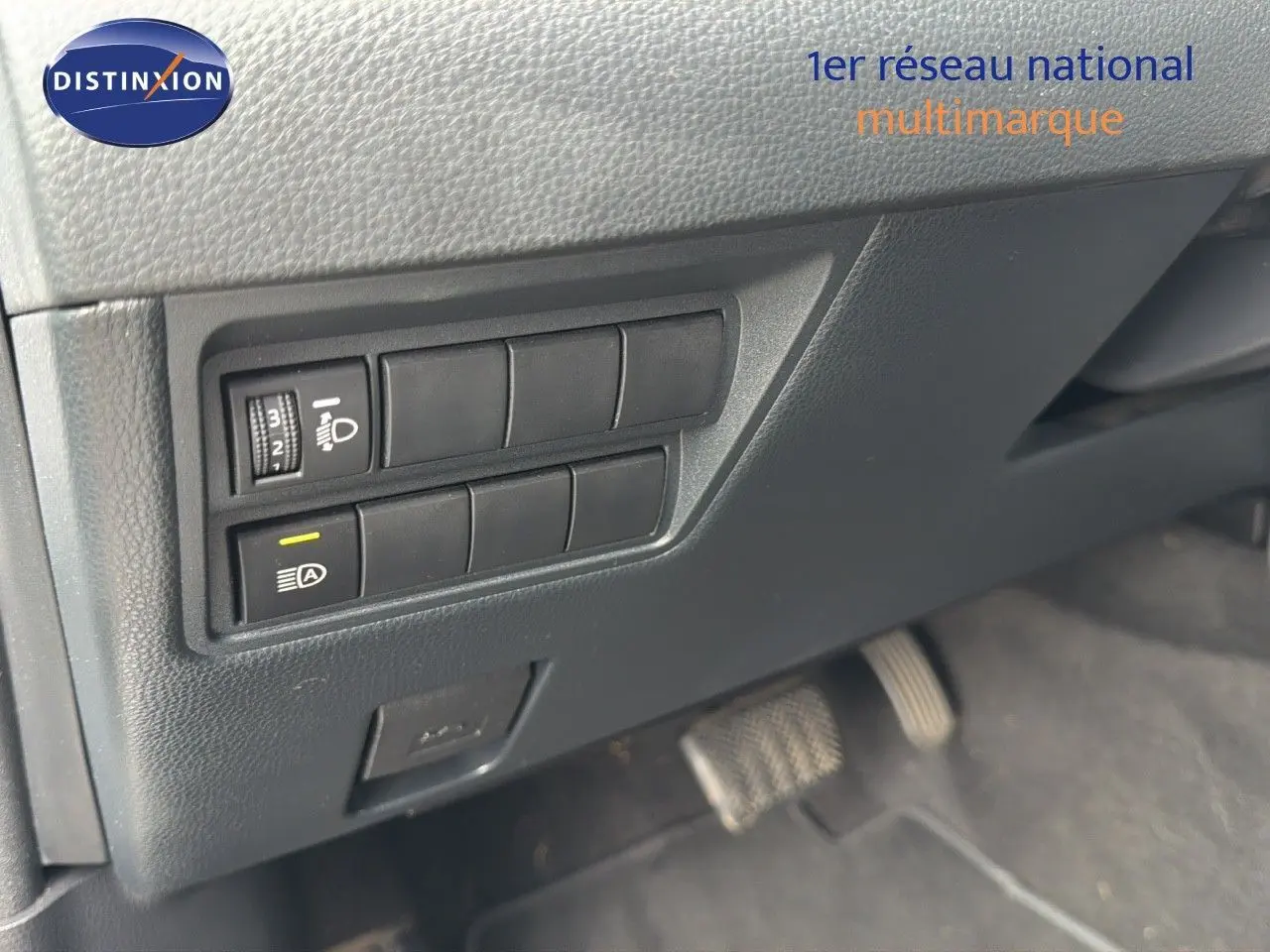 Gros plan sur les commandes d'éclairage et l'intérieur noir du Toyota Yaris Cross 116h Design AWD-i 2023.