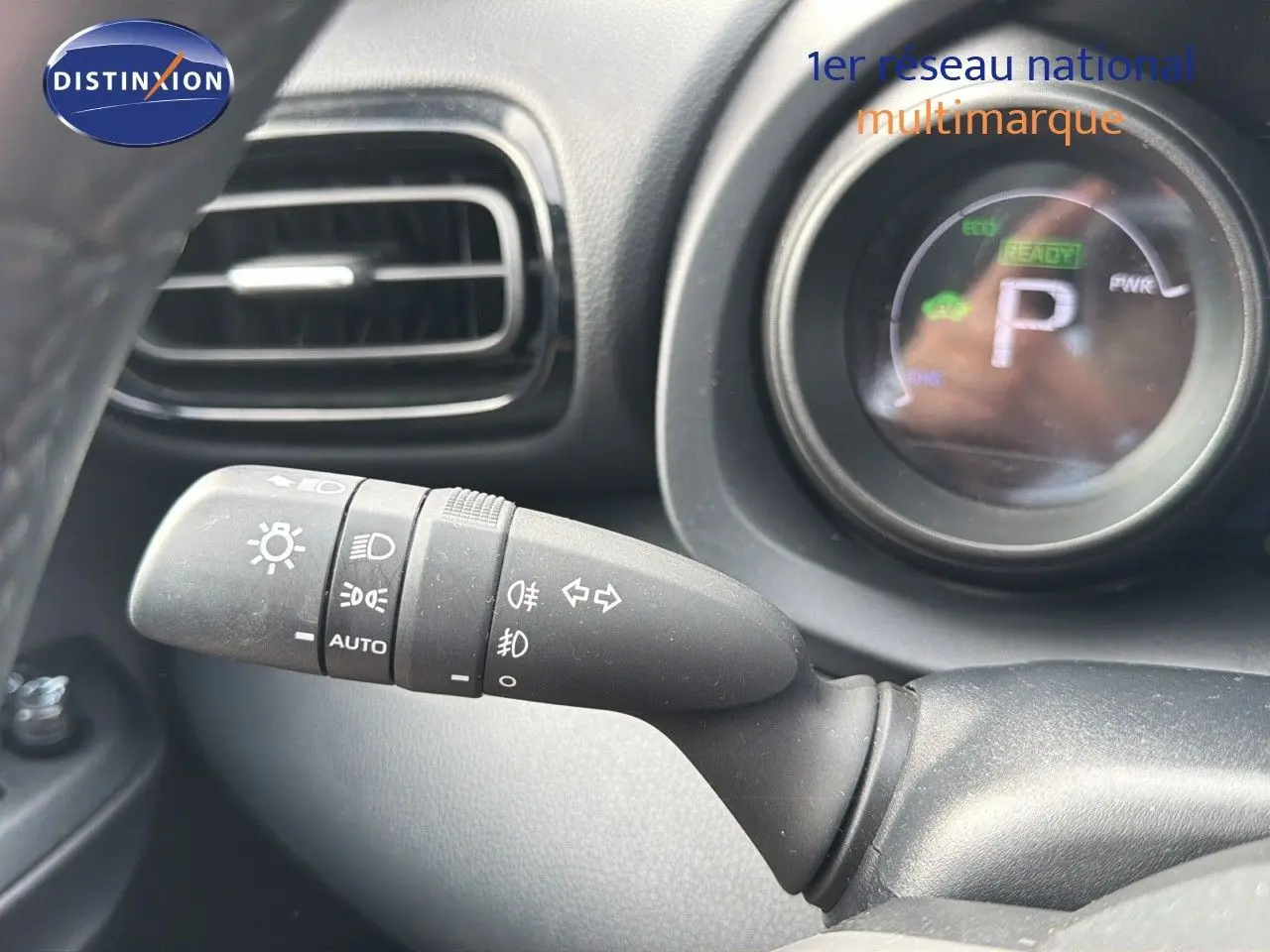 Gros plan sur la commande des phares et clignotants dans l'habitacle noir de la Toyota Yaris Cross hybride 2023.