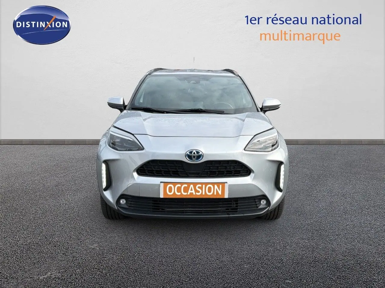 Vue frontale d'une Toyota Yaris Cross 116h Design AWD-i 2023 en gris minéral avec feux LED et calandre noire.