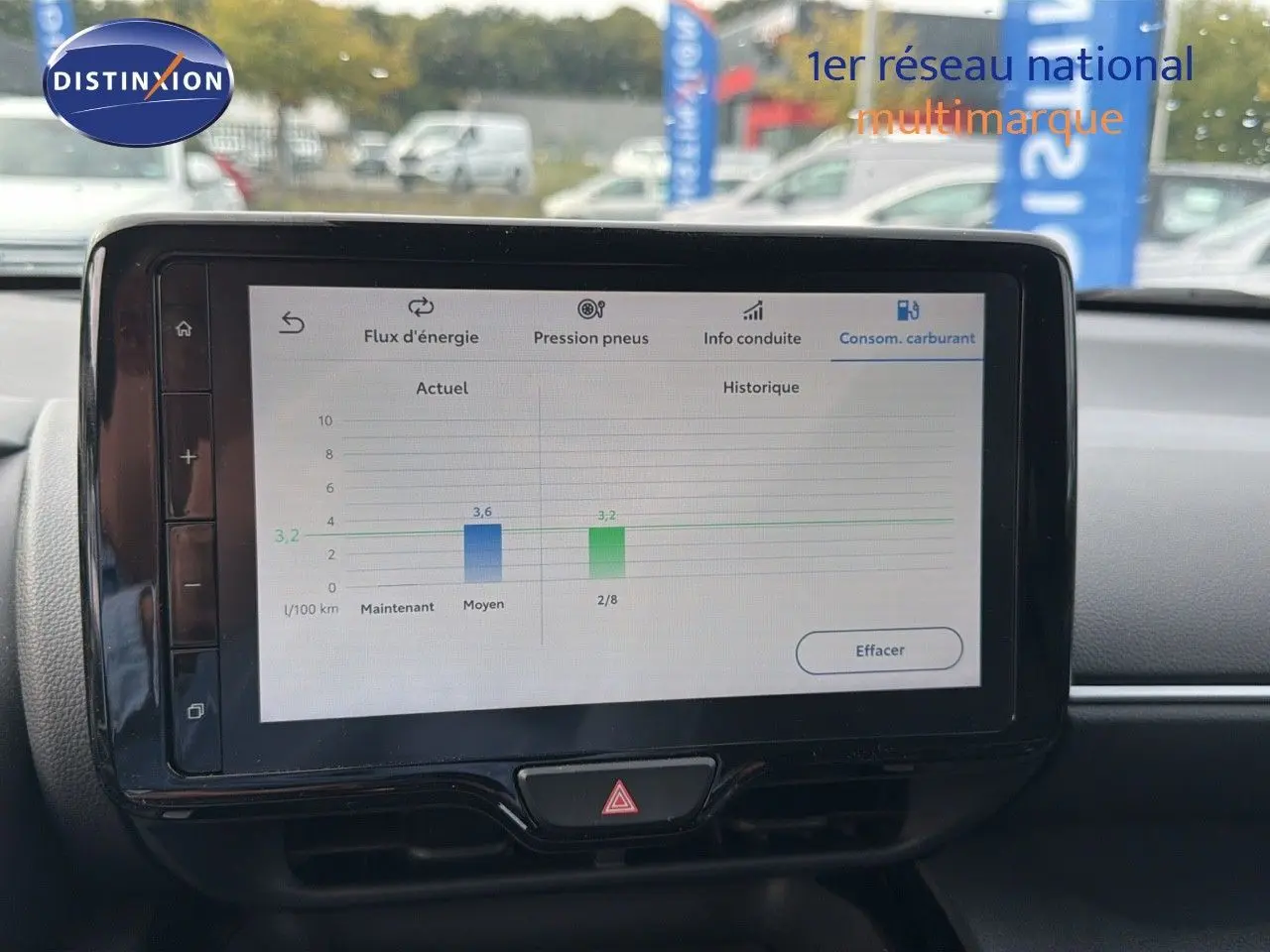 Écran tactile central affichant la consommation de carburant dans l'habitacle d'une Toyota Yaris Cross gris minéral 2023.
