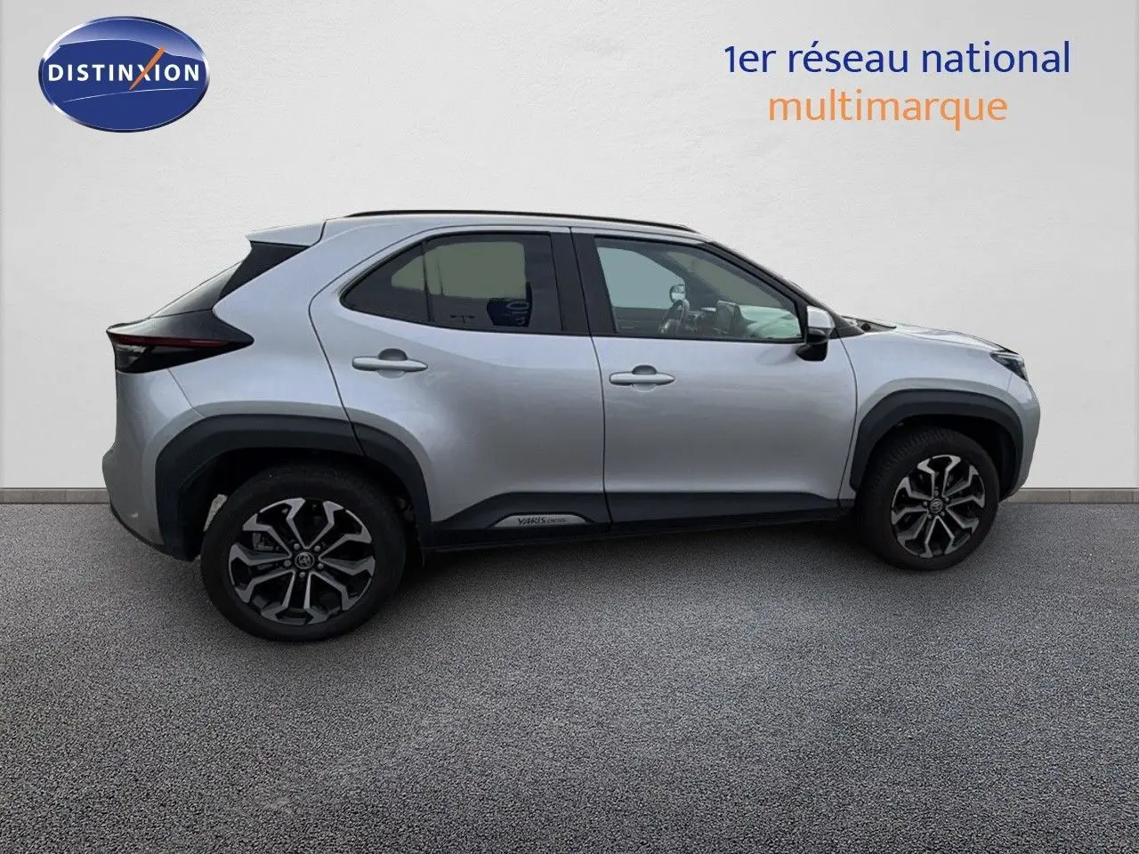 Profil droit d'une Toyota Yaris Cross gris minéral 2023 avec jantes bi-ton et détails noirs contrastants.