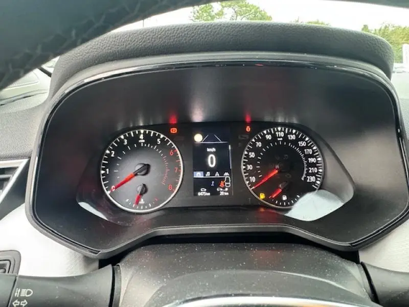 Vue rapprochée du tableau de bord noir de la Renault Clio blanc glacier 2023 avec compte-tours et vitesse digitale à zéro.