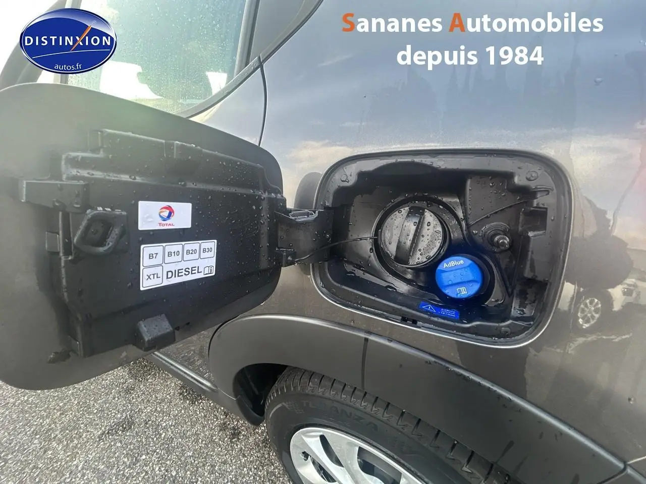 Trappe à carburant ouverte côté gauche sur Citroën C3 gris foncé 2023, bouchon AdBlue visible et étiquette diesel.