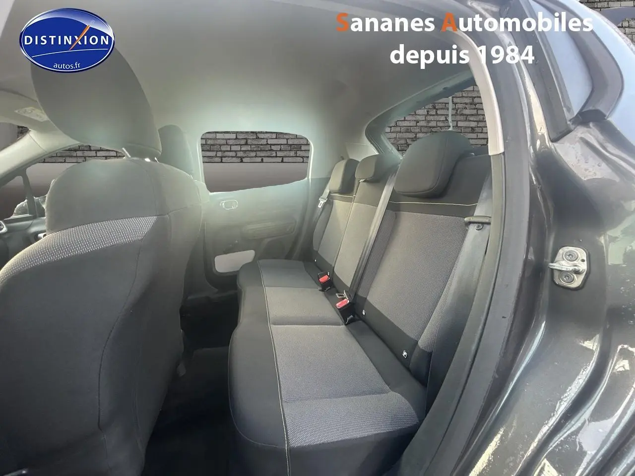 Vue intérieure arrière côté droit de la Citroën C3 2023 gris foncé, montrant les sièges arrière en tissu Mica Grey.