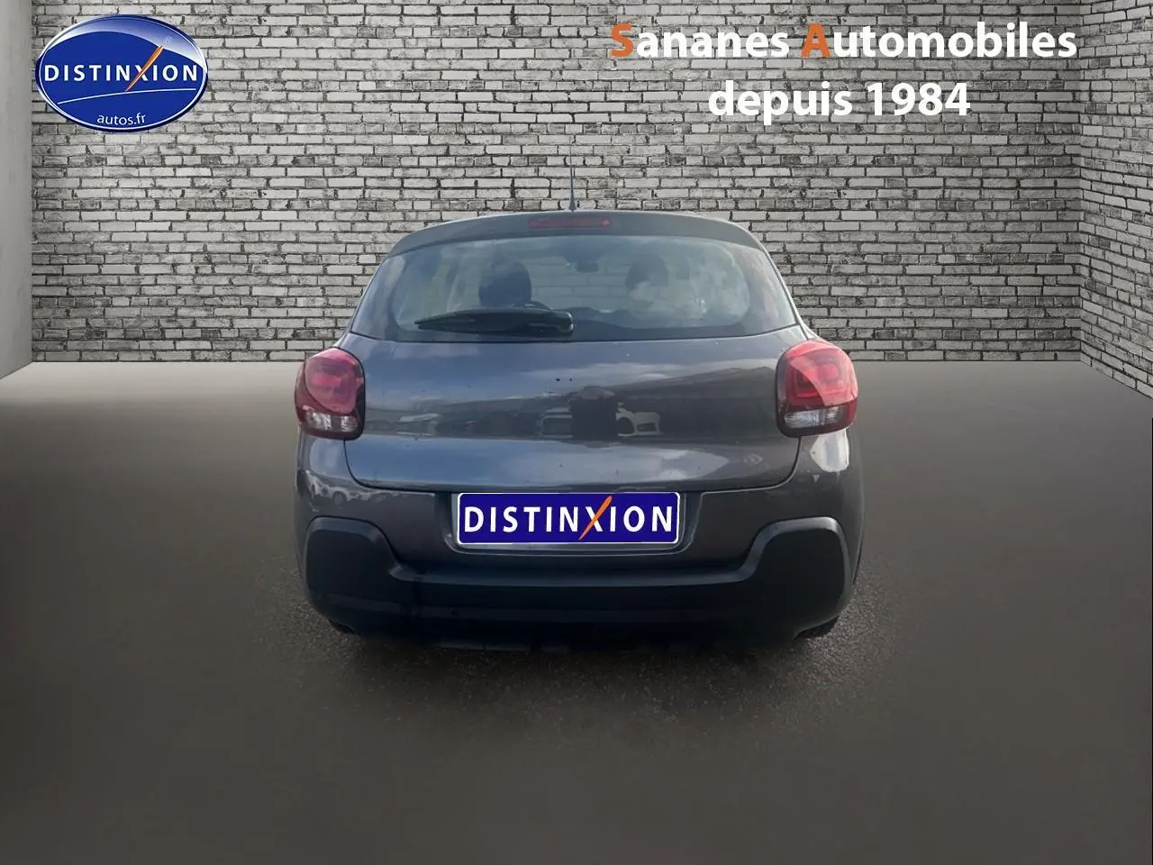 Vue arrière d'une Citroën C3 1.5 BlueHDi 100 Feel Business gris foncé, avec feux arrière arrondis et pare-chocs noir.