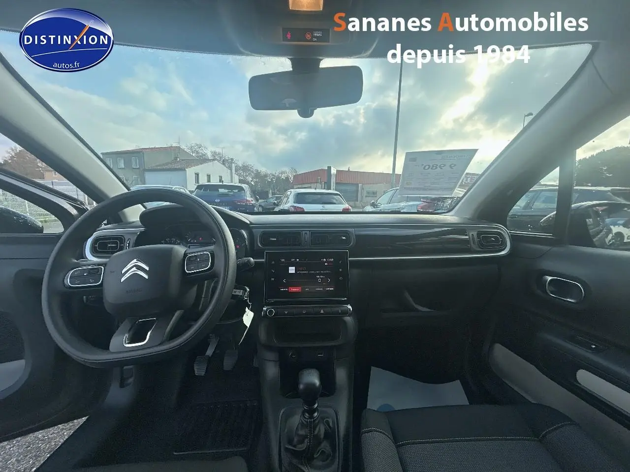 Vue intérieure avant de la Citroën C3 2023 gris foncé, volant multifonction et écran tactile central visible.