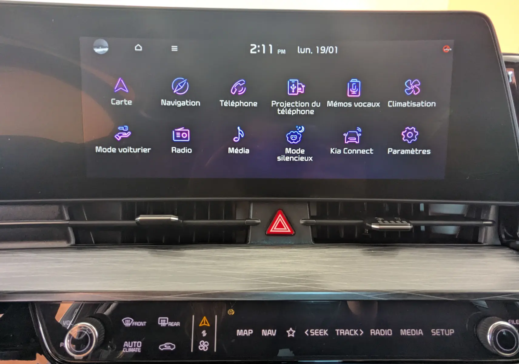 Écran tactile central du tableau de bord du Kia Sportage 2025 affichant les icônes de navigation, téléphone et climatisation.