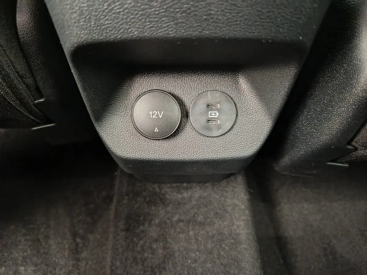 Prise 12V et double port USB-C vue en gros plan à l'arrière des sièges d'un Ford Puma bleu 2025.