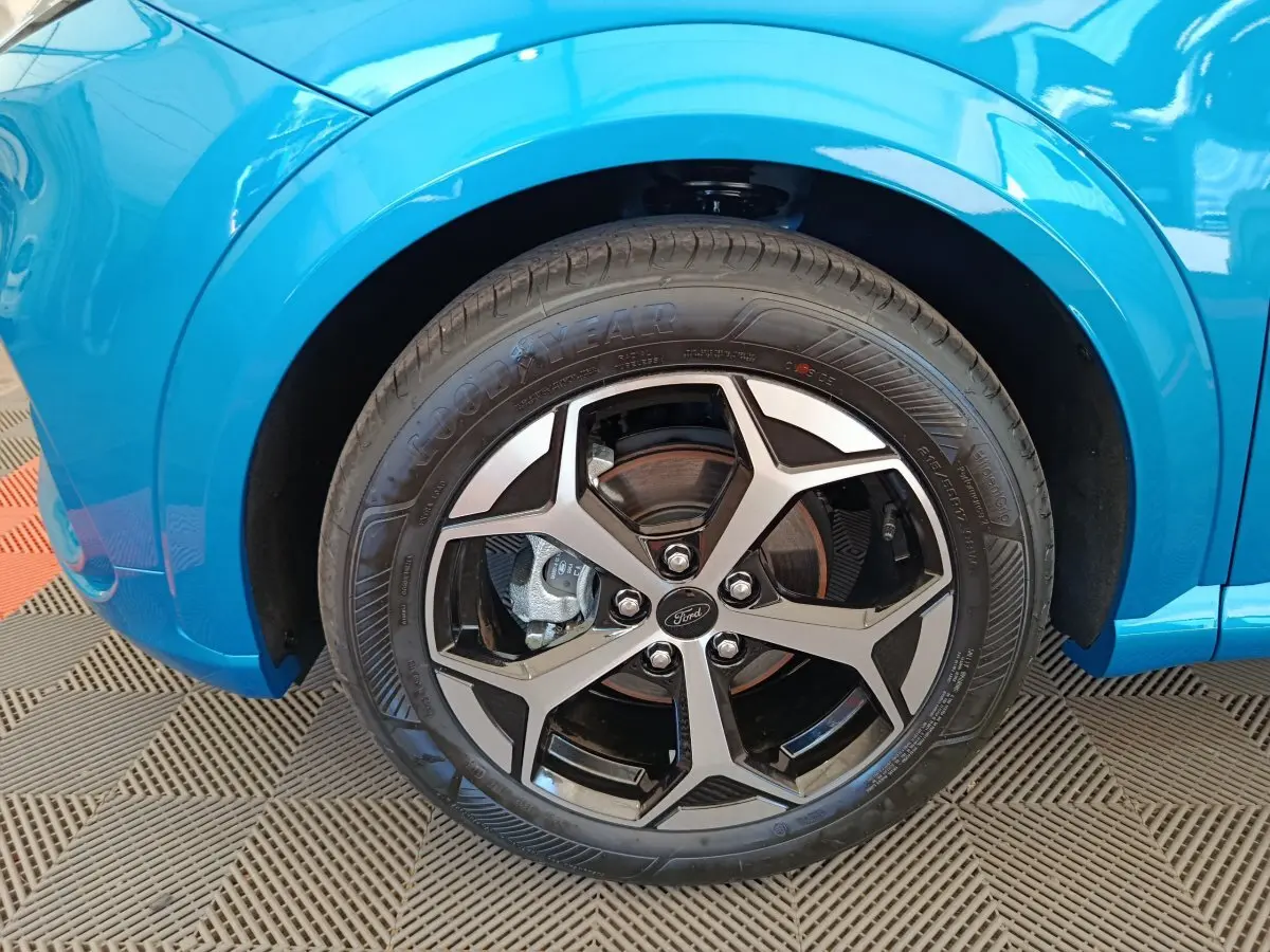 Gros plan sur la roue avant droite du Ford Puma bleu 2025 avec jante alliage noire et argentée.