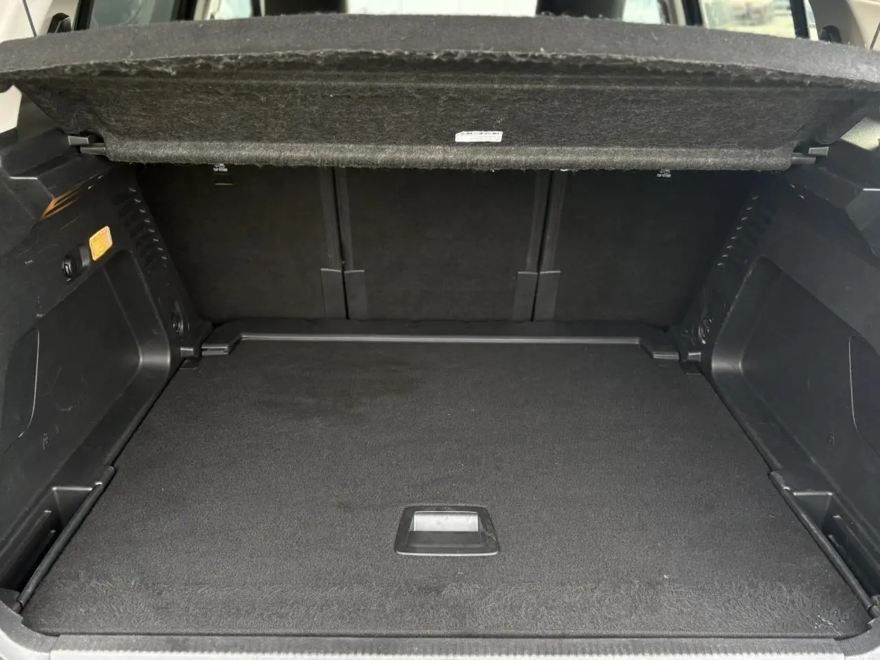 Coffre ouvert vu de l'arrière d'un Citroën C5 Aircross gris Platinium, montrant un espace de chargement spacieux et noir.