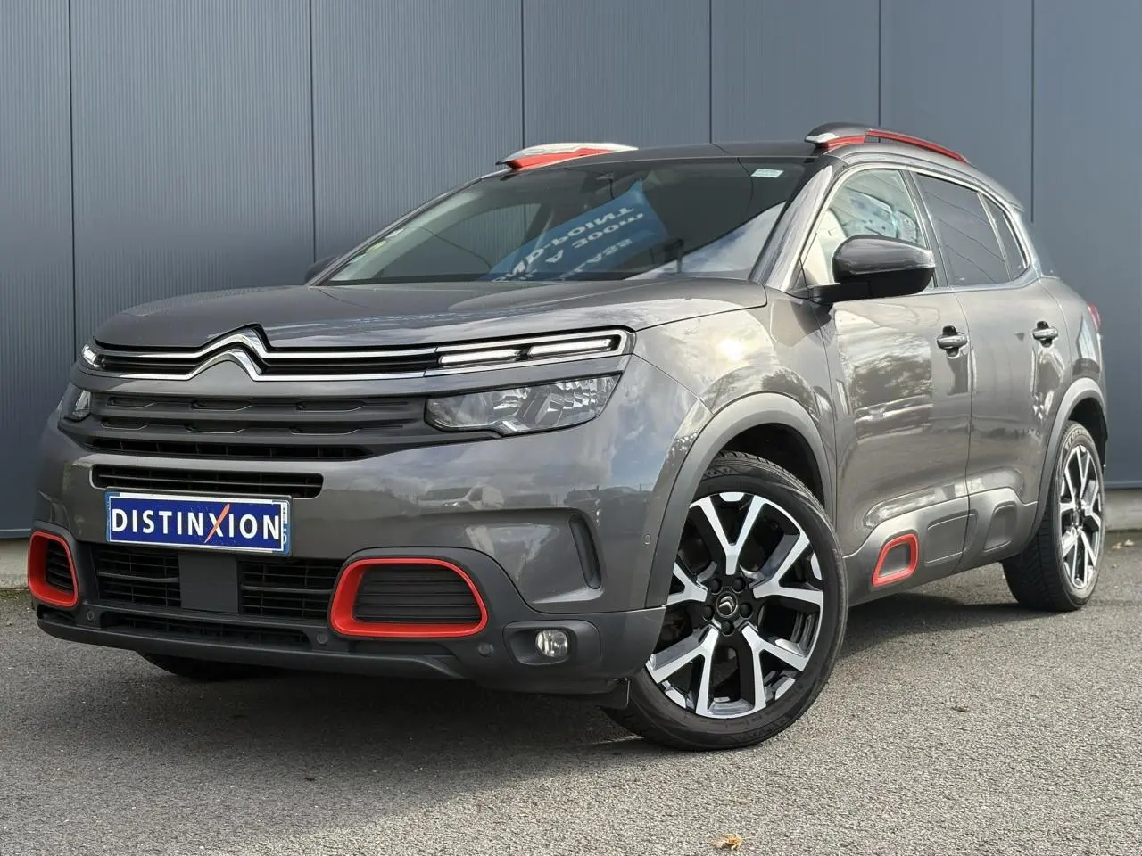 Vue 3/4 avant droit du Citroën C5 Aircross gris Platinium avec inserts rouges et jantes alliage 19 pouces diamantées.