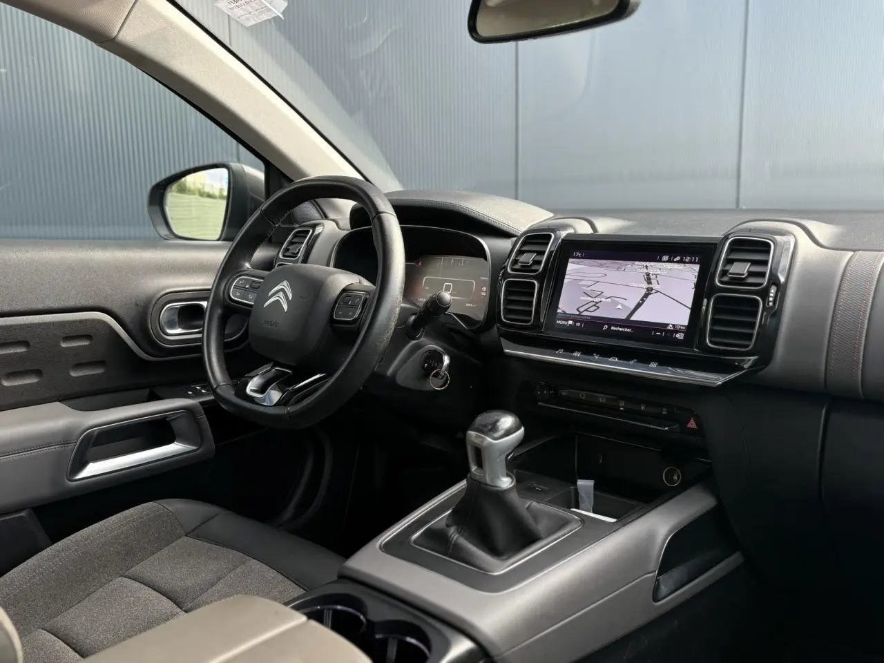 Intérieur du Citroën C5 Aircross 2020 côté conducteur, volant cuir, écran GPS tactile et levier de vitesses manuel.