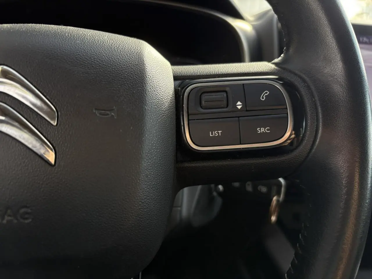 Gros plan sur les commandes du volant en cuir noir du Citroën C5 Aircross 2020, version Feel.