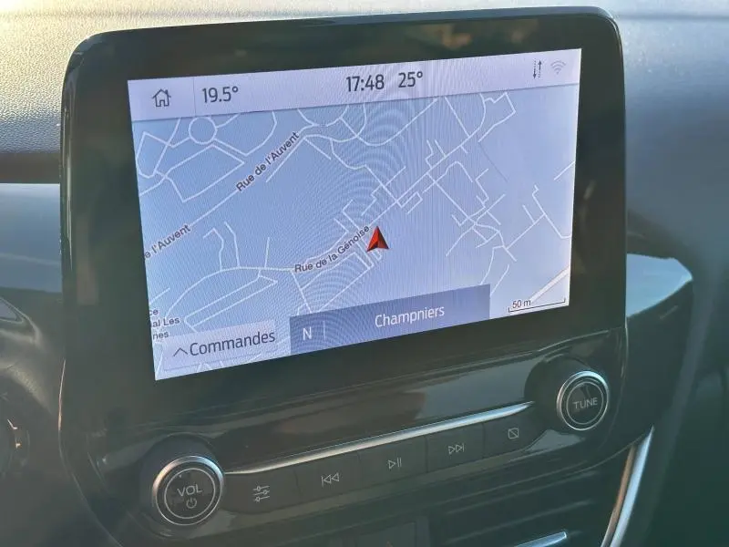 Écran tactile central du Ford Puma 2024 montrant la navigation avec carte et commandes intégrées, ambiance intérieure noire.