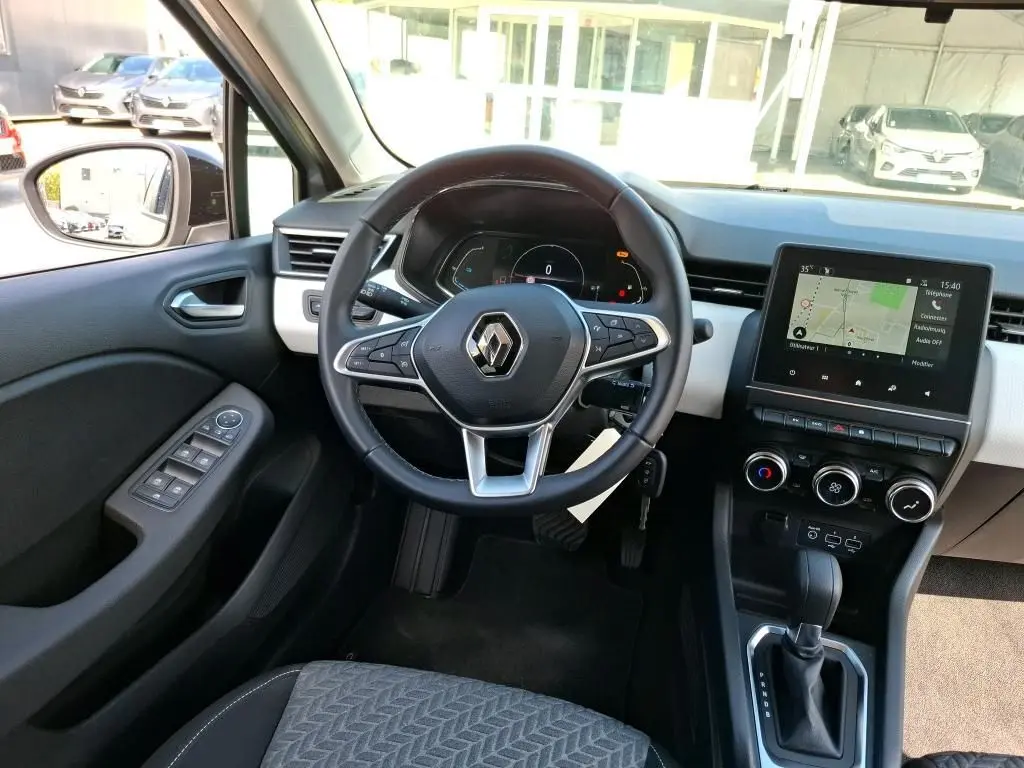 Vue intérieure de face du volant et tableau de bord de la Renault Clio 1.6 E-Tech gris platine avec écran tactile et boîte automatique.