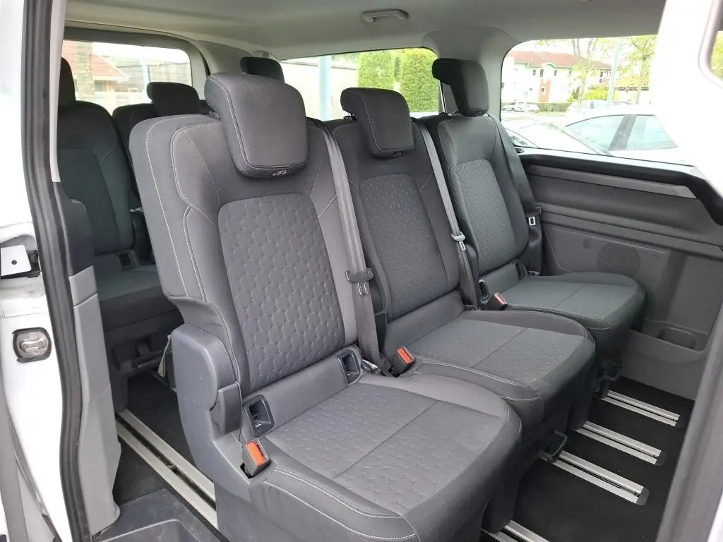 Vue intérieure côté droit des sièges individuels noirs de la 3ème rangée du Ford Tourneo Custom blanc 2024.