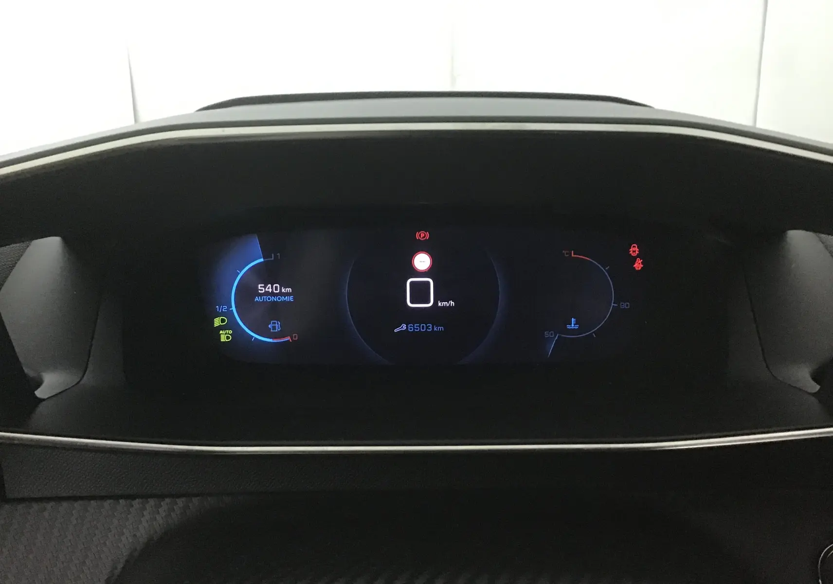 Tableau de bord numérique de Peugeot 208 1.2 PureTech 100 GT S&S affichant autonomie et kilométrage, ambiance sombre intérieure.