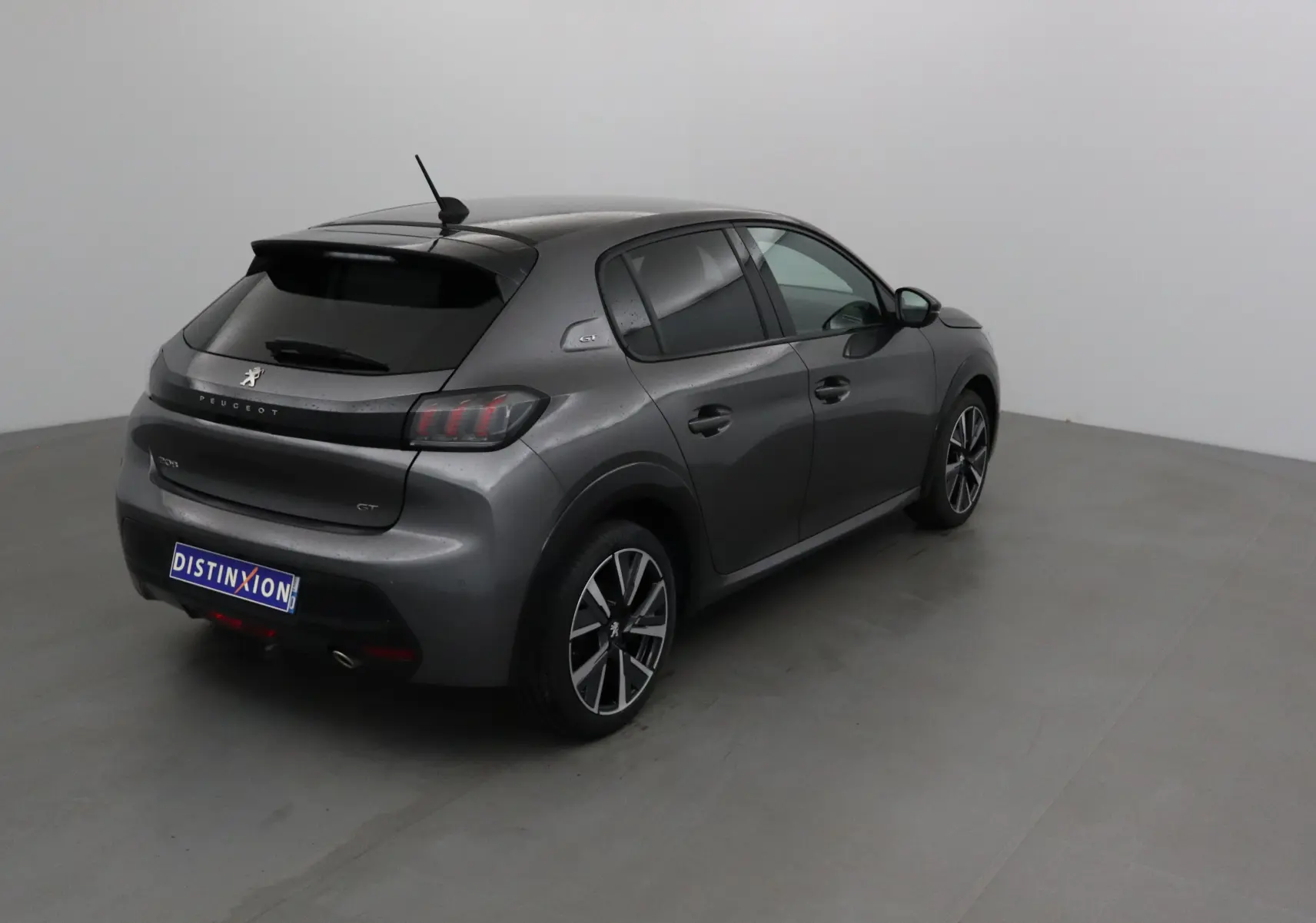 Vue 3/4 arrière droite d'une Peugeot 208 GT 2023 gris platinium avec jantes alliage et vitres teintées.